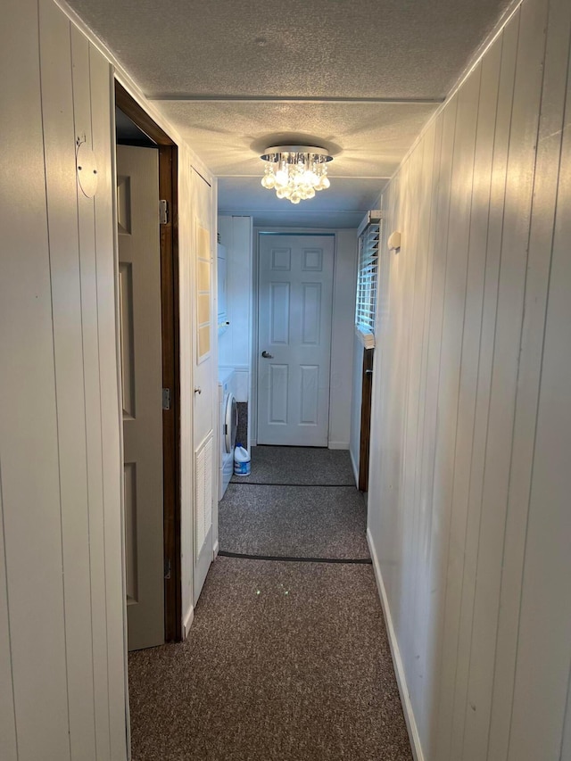 12030 Holly Dr Unit 31, Lakeview, OH 43331 - hall featuring a textured ceiling, washer / clothes dryer, baseboards, a chandelier, and dark carpet
