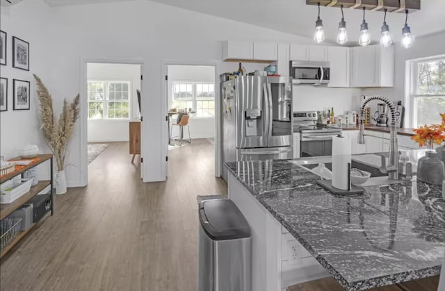 4320 Jacktown Rd, Ostrander, OH 43061 - kitchen featuring stainless steel appliances, white cabinets, a sink, wood finished floors, and vaulted ceiling