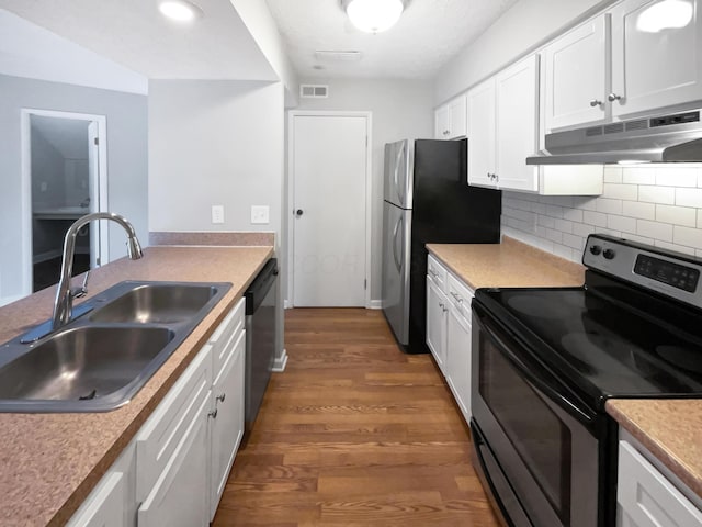 1813 Worthington Run Dr Unit A, Columbus, OH 43235 - kitchen with stainless steel appliances, under cabinet range hood, a sink, wood finished floors, and white cabinetry