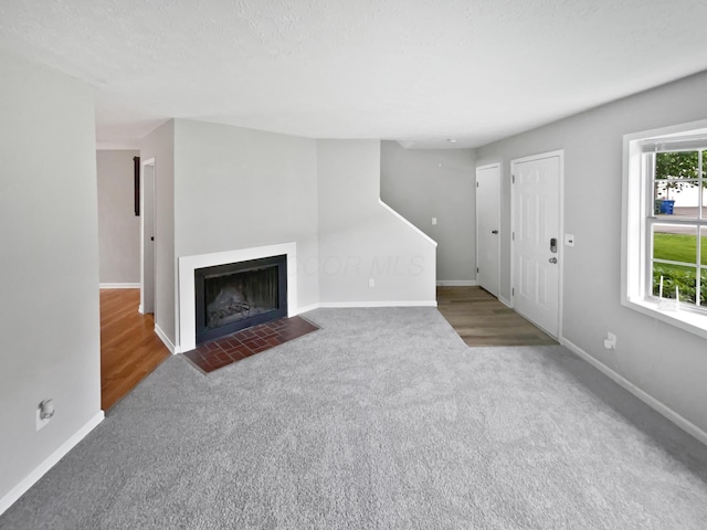 1813 Worthington Run Dr Unit A, Columbus, OH 43235 - unfurnished living room featuring carpet flooring, baseboards, and a fireplace with flush hearth