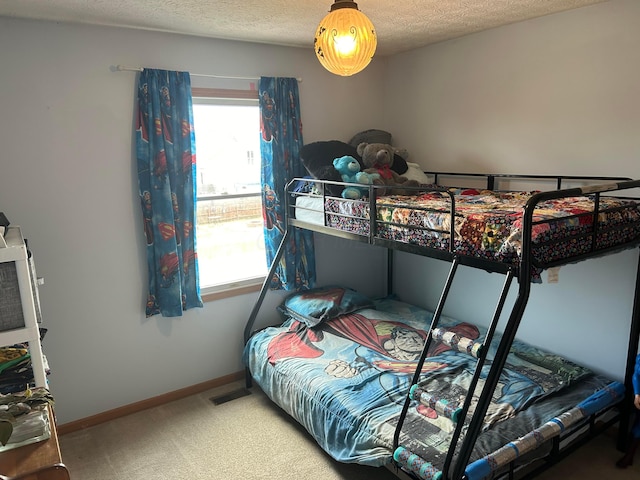 carpeted bedroom featuring baseboards and a textured ceiling