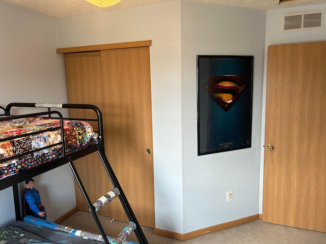 carpeted bedroom with baseboards and a textured ceiling