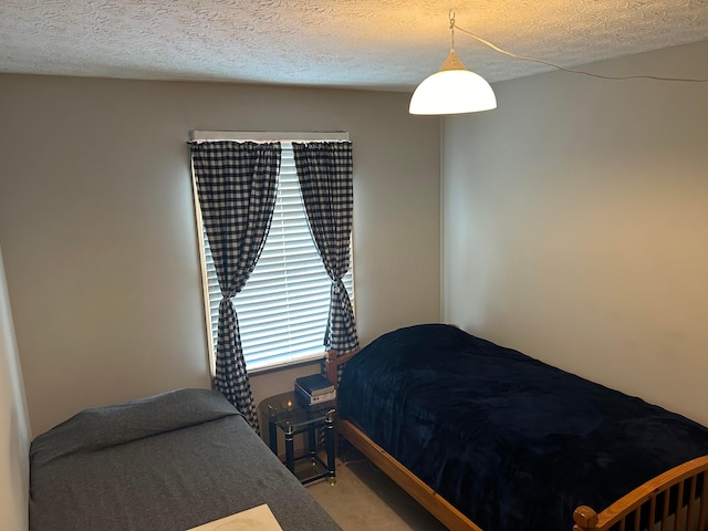 bedroom with light carpet and a textured ceiling