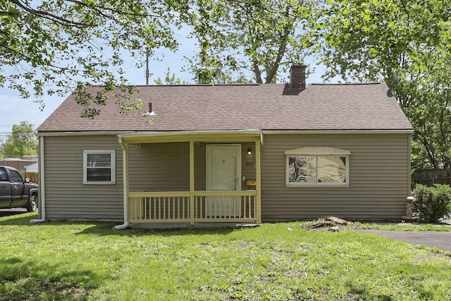 392 S Hampton Rd, Columbus, OH 43213 - view of front facade featuring roof with shingles, a front lawn, and a chimney