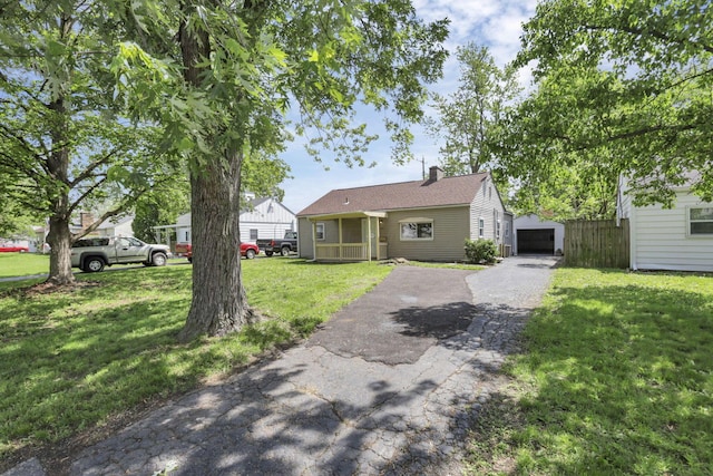 392 S Hampton Rd, Columbus, OH 43213 - view of front of property with asphalt driveway, a front lawn, an outbuilding, and a detached garage