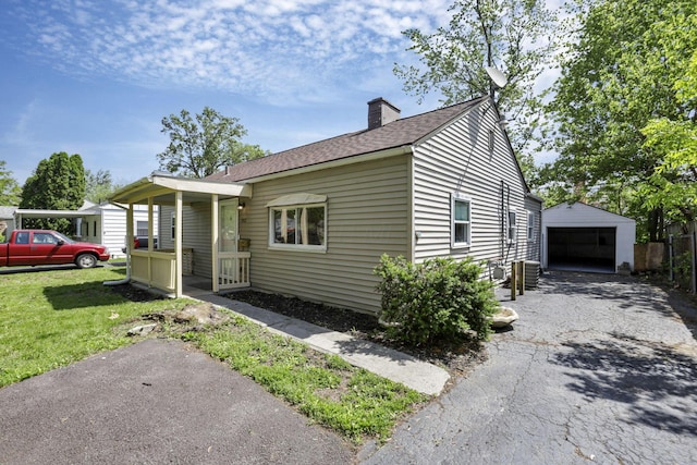 392 S Hampton Rd, Columbus, OH 43213 - view of front of property with a detached garage, an outbuilding, a chimney, central AC, and roof with shingles