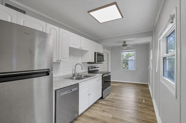 392 S Hampton Rd, Columbus, OH 43213 - kitchen with appliances with stainless steel finishes, a sink, white cabinets, light wood-style flooring, and ornamental molding