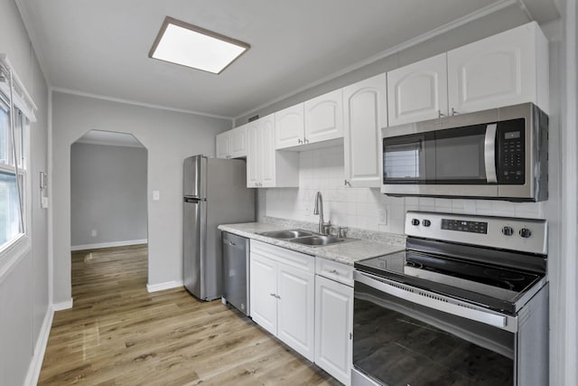 392 S Hampton Rd, Columbus, OH 43213 - kitchen featuring stainless steel appliances, a sink, arched walkways, crown molding, and white cabinets