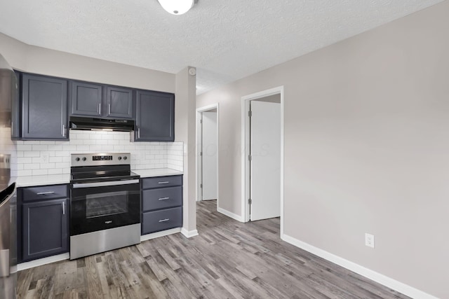 3197 E Ave, Columbus, OH 43207 - kitchen featuring stainless steel electric range, under cabinet range hood, light countertops, baseboards, and light wood-type flooring