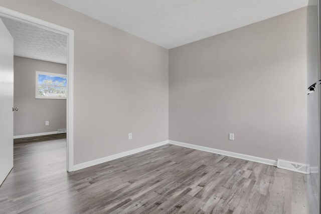 3197 E Ave, Columbus, OH 43207 - empty room featuring wood finished floors, baseboards, and a textured ceiling