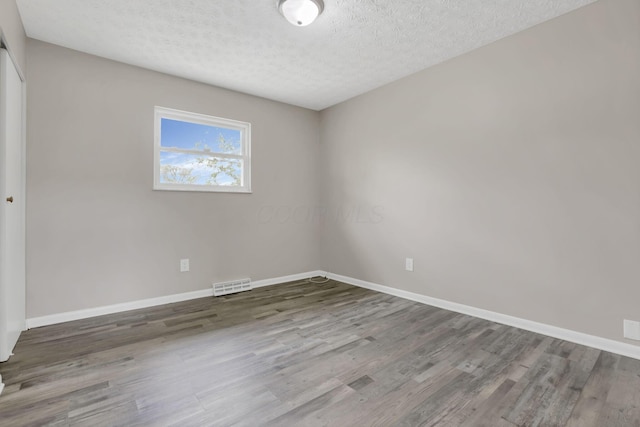 3197 E Ave, Columbus, OH 43207 - spare room with wood finished floors, baseboards, and a textured ceiling