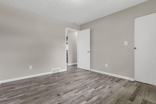 3197 E Ave, Columbus, OH 43207 - spare room with wood finished floors, a textured ceiling, and baseboards