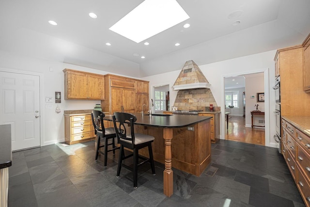 366 W S St, Worthington, OH 43085 - kitchen with a kitchen bar, recessed lighting, a center island with sink, a skylight, and custom exhaust hood