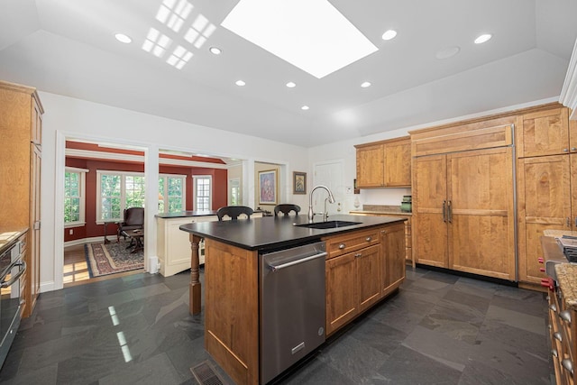 366 W S St, Worthington, OH 43085 - kitchen featuring stainless steel dishwasher, a kitchen bar, dark countertops, a kitchen island with sink, and a skylight