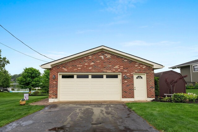 1244 E Choctaw Dr, London, OH 43140 - view of front of home with brick siding, asphalt driveway, a front lawn, and an outbuilding