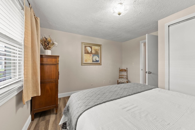 1244 E Choctaw Dr, London, OH 43140 - bedroom featuring wood finished floors, baseboards, a textured ceiling, and a closet