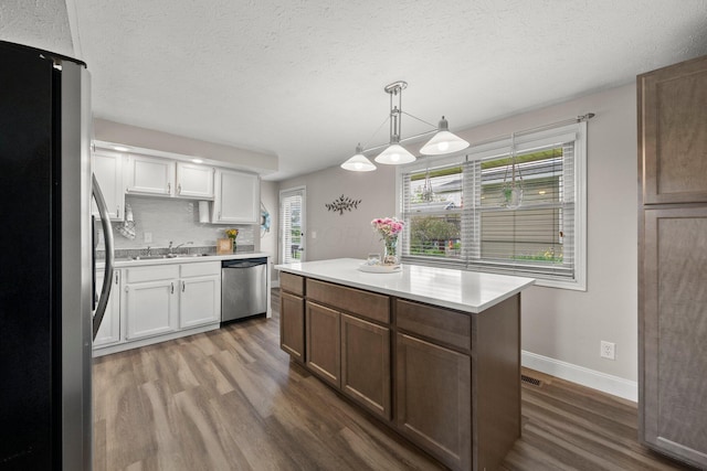 1244 E Choctaw Dr, London, OH 43140 - kitchen with stainless steel appliances, dark wood-style floors, healthy amount of natural light, light countertops, and a textured ceiling