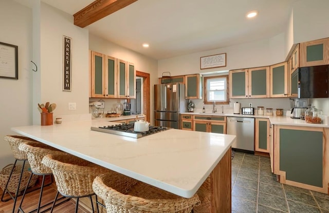 841 E Mulberry St, Lancaster, OH 43130 - kitchen featuring stainless steel appliances, a peninsula, a breakfast bar, light countertops, and glass insert cabinets