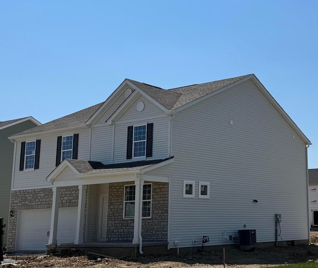 1283 Andean Dr Lot 69, Lockbourne, OH 43137 - view of home's exterior featuring covered porch, a garage, stone siding, and a shingled roof