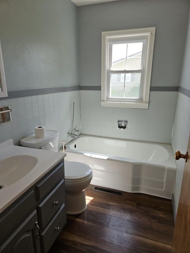 36 Johnson Rd, The Plains, OH 45780 - full bath featuring tile walls, toilet, hardwood / wood-style flooring, a bath, and a wainscoted wall
