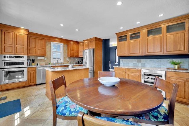 609 Mohawk St, Columbus, OH 43206 - kitchen featuring stainless steel appliances, decorative backsplash, a sink, wine cooler, and a center island