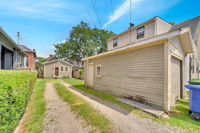 609 Mohawk St, Columbus, OH 43206 - view of side of home with a garage, dirt driveway, and an outbuilding