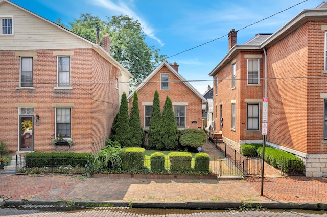 609 Mohawk St, Columbus, OH 43206 - view of front facade featuring a fenced front yard, a gate, brick siding, and a chimney