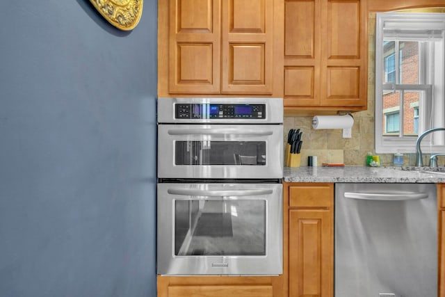 609 Mohawk St, Columbus, OH 43206 - kitchen with stainless steel appliances, backsplash, light stone countertops, and a sink