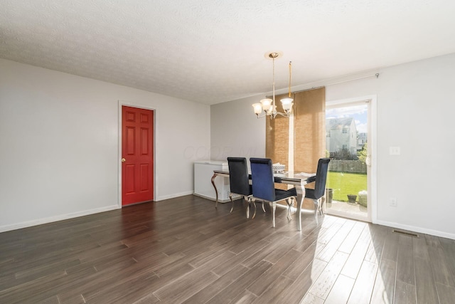 dining room featuring dark wood-style flooring, a chandelier, and baseboards
