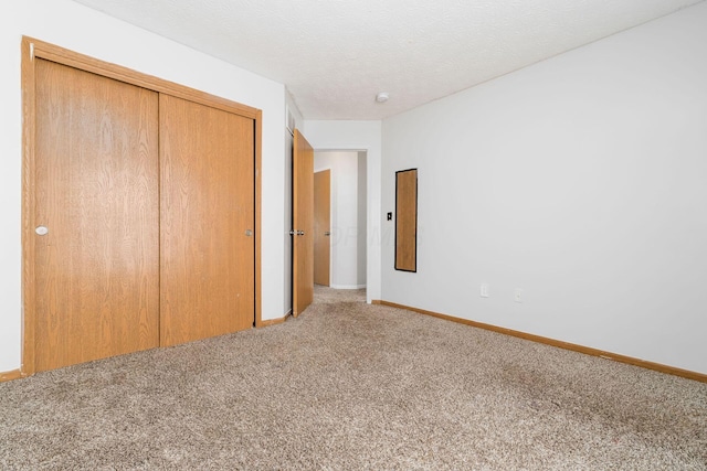 unfurnished bedroom with carpet, a closet, and baseboards