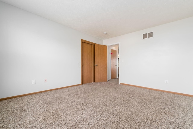 unfurnished room featuring light carpet and baseboards