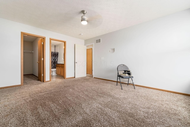 unfurnished bedroom featuring carpet flooring, a walk in closet, and baseboards