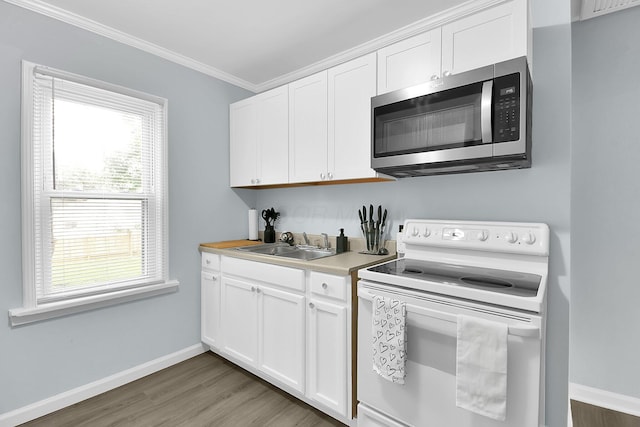 523 S Napoleon Ave, Columbus, OH 43213 - kitchen with stainless steel microwave, electric range, a sink, wood finished floors, and ornamental molding
