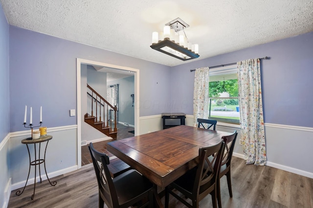 214 Sylvan Dr, Delaware, OH 43015 - dining room with a textured ceiling, wood finished floors, stairway, baseboards, and a chandelier