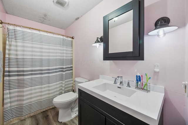 214 Sylvan Dr, Delaware, OH 43015 - full bath featuring wood finished floors, toilet, a textured ceiling, vanity, and curtained shower