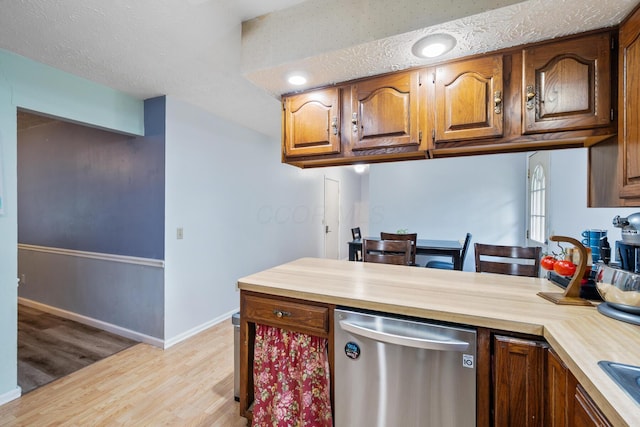 214 Sylvan Dr, Delaware, OH 43015 - kitchen with dishwasher, light wood-type flooring, a peninsula, brown cabinetry, and baseboards