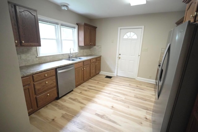 723 N Maple St, Lancaster, OH 43130 - kitchen featuring appliances with stainless steel finishes, a sink, tasteful backsplash, light wood-style floors, and healthy amount of natural light