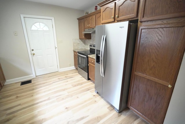 723 N Maple St, Lancaster, OH 43130 - kitchen featuring appliances with stainless steel finishes, under cabinet range hood, light wood-style flooring, tasteful backsplash, and baseboards
