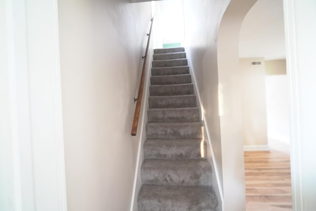 723 N Maple St, Lancaster, OH 43130 - stairway featuring arched walkways, wood finished floors, and baseboards