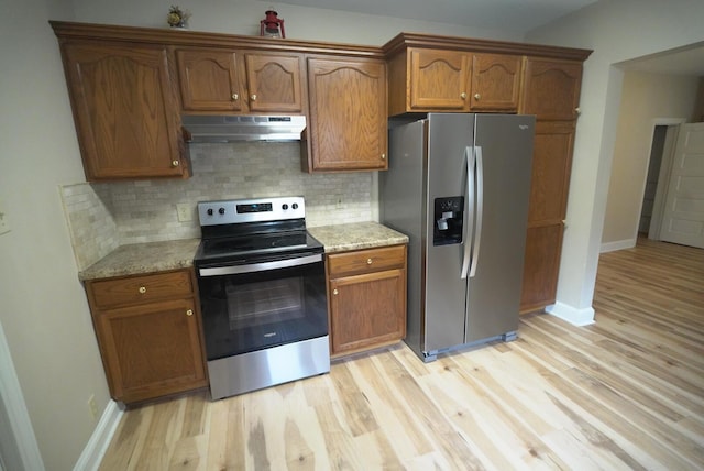 723 N Maple St, Lancaster, OH 43130 - kitchen featuring stainless steel appliances, under cabinet range hood, light wood-type flooring, decorative backsplash, and baseboards