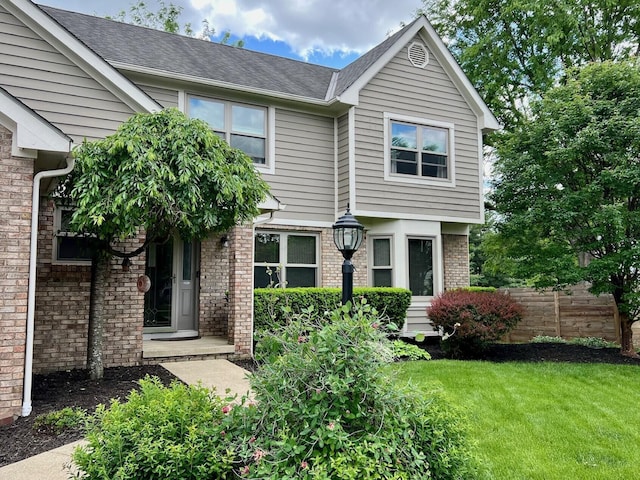 view of front of property with brick siding and a shingled roof