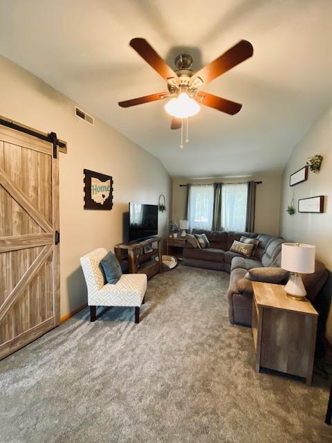 281 Bexford Rd, West Jefferson, OH 43162 - carpeted living area with lofted ceiling, a barn door, and a ceiling fan