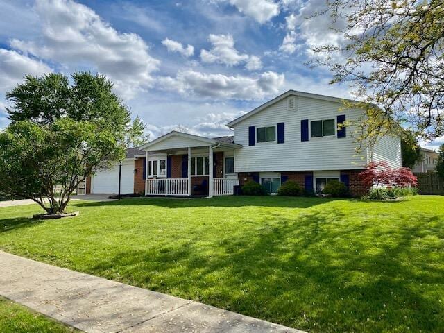 281 Bexford Rd, West Jefferson, OH 43162 - split level home featuring a porch, a front lawn, a garage, and brick siding