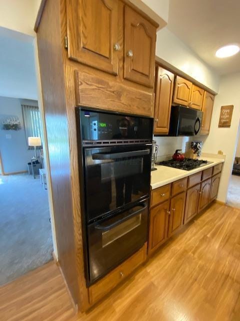 281 Bexford Rd, West Jefferson, OH 43162 - kitchen with black appliances, light wood finished floors, brown cabinets, light countertops, and a warming drawer