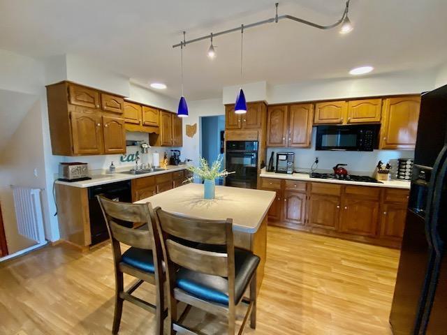 281 Bexford Rd, West Jefferson, OH 43162 - kitchen featuring black appliances, brown cabinetry, rail lighting, and light countertops