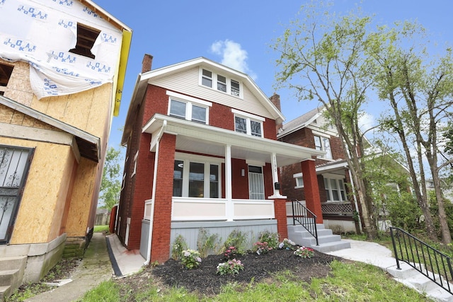 1195 E Whittier St, Columbus, OH 43206 - american foursquare style home featuring a porch, brick siding, and a chimney