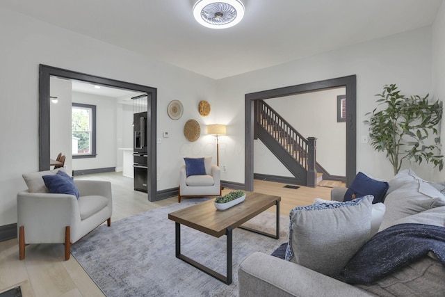 1195 E Whittier St, Columbus, OH 43206 - living room with light wood finished floors, stairway, and baseboards