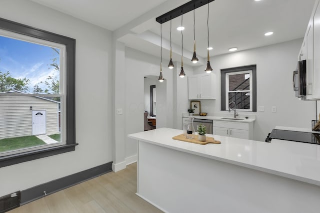 1195 E Whittier St, Columbus, OH 43206 - kitchen featuring a sink, light wood-style flooring, white cabinets, stainless steel appliances, and light countertops