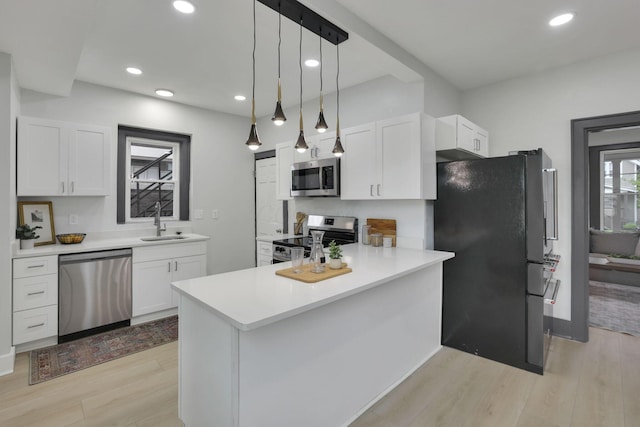 1195 E Whittier St, Columbus, OH 43206 - kitchen with appliances with stainless steel finishes, a sink, light wood-type flooring, white cabinets, and light countertops