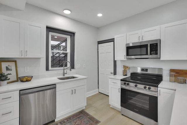 1195 E Whittier St, Columbus, OH 43206 - kitchen featuring stainless steel appliances, a sink, white cabinets, light countertops, and recessed lighting